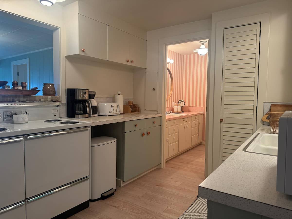 The kitchen, with the pink bathroom beyond it.